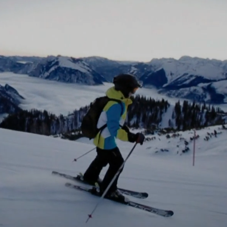 Ein Junge fährt in den Bergen Skier.